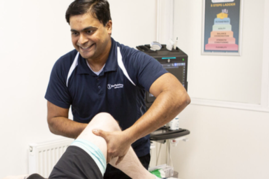 Physiotherapist assessing knee for osteoarthritis injection therapy 